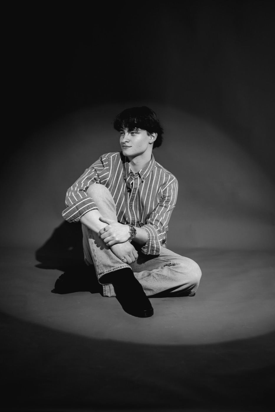 Elvin Sharpe sitting in a spotlight, black and white